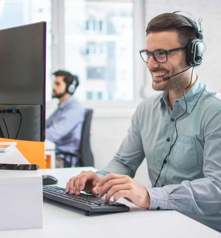 Energia+ Pomoc IT. Konsultant ze słuchawkami zdalnie pomaga klientom