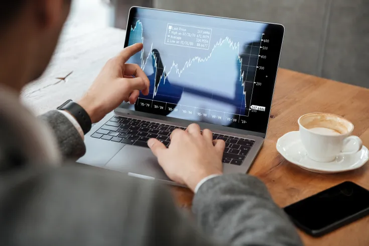 cropped-image-businessman-sitting-by-table-cafe-analyzing-indicators-laptop-computer
